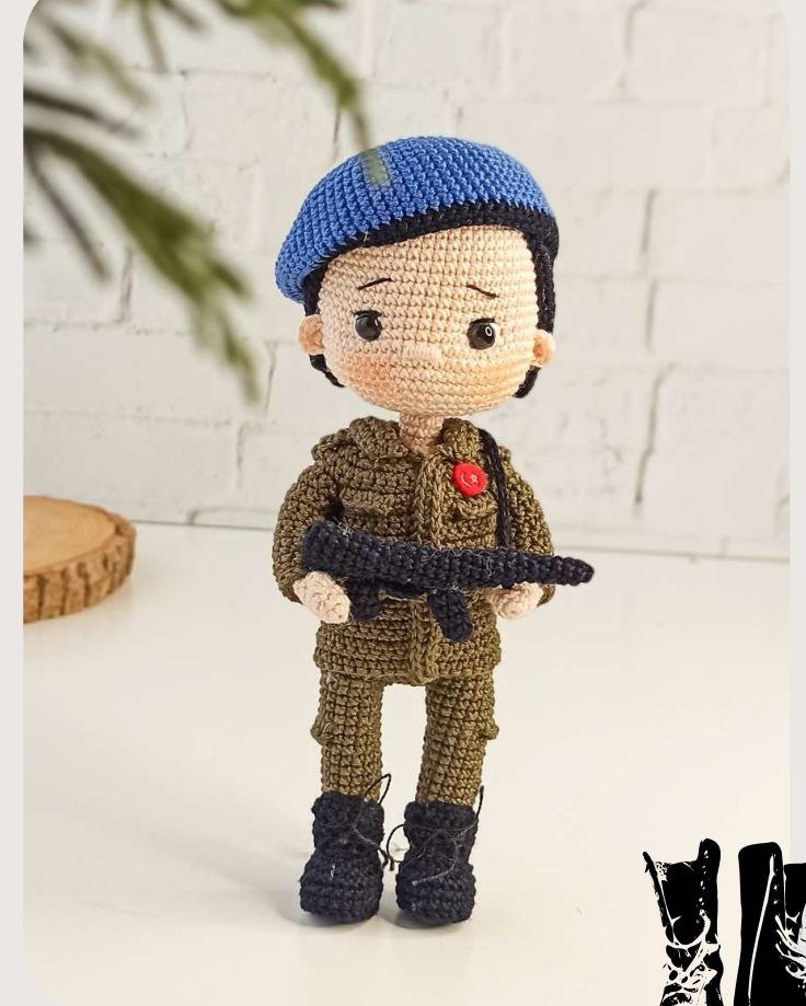 Crocheted soldier figure with weapon, highlighting its uniform and determined expression.