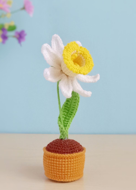 Crocheted daffodil in a pot, showcasing a colorful and delicate design.