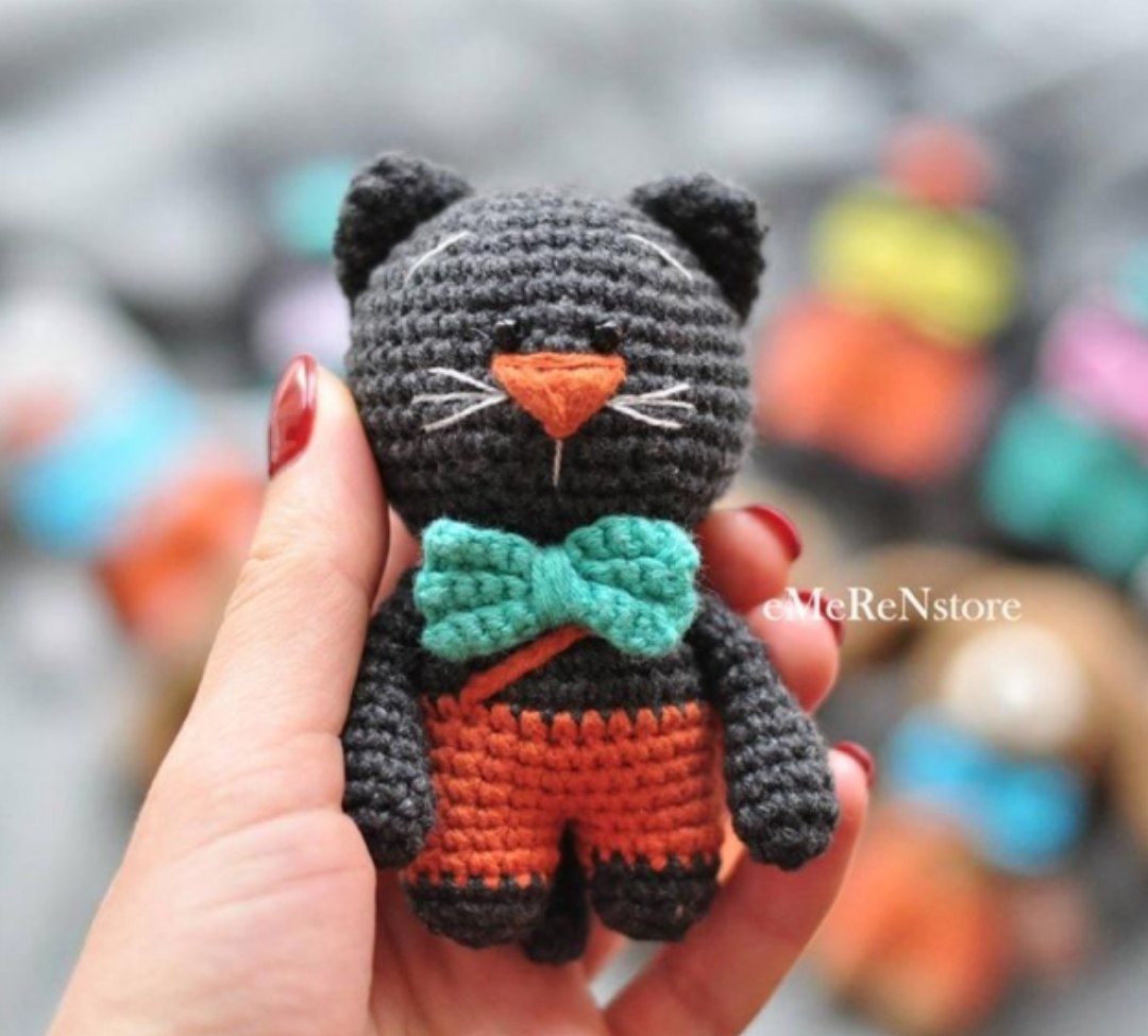 Small crochet cat with an elegant bow, showcasing a charming and detailed design, perfect for animal lovers and creative projects.