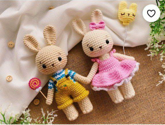 Two crochet bunnies holding hands, showcasing a sweet bond between them, perfect for decorating a cozy space and adding a touch of cuteness.