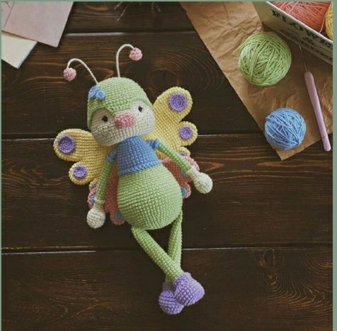 Crochet butterfly doll with a green dress and yellow wings, highlighting its handcrafted beauty.