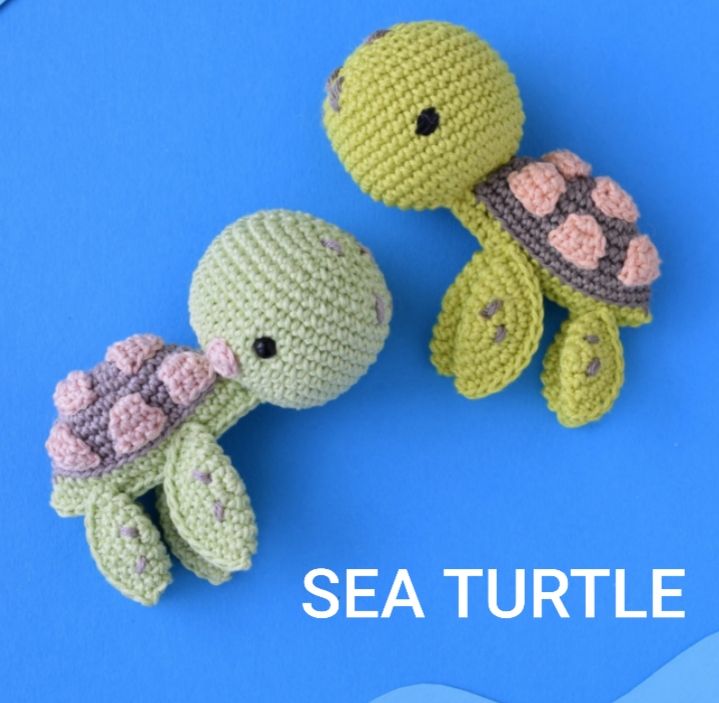 Two small crochet turtles on a blue background, showcasing their colorful and delicate handmade design.