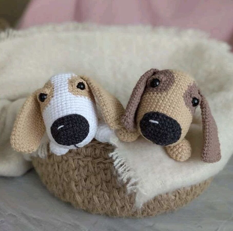 Two dogs in a basket next to a crochet design, set against a colorful background.
