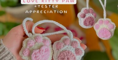 Crocheted cat paws in white and pink, with a loving design, perfect for cat lovers and crafters.